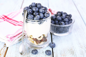 Fototapeta na wymiar Natural yogurt with fresh blueberries on wooden table