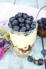 Natural yogurt with fresh blueberries on wooden table