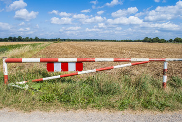 Barrier between gravel road and field