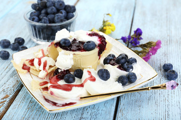 Tasty dessert with fresh blueberries on wooden table