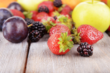 Ripe fruits and berries on wooden background