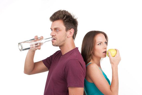 young man and woman with water and apple.