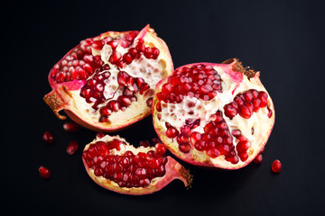 Ripe pomegranate fruit on black background