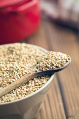 uncooked buckwheat on wooden spoon