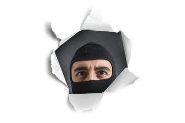 Thief looking through a paper hole