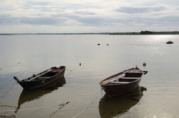 Fototapeta na wymiar Two old wooden rowing boats by the coast