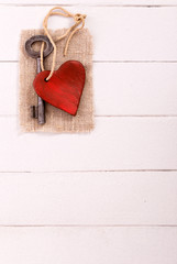 Old  key with a heart on white vertical