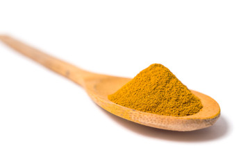 Milled curcuma on wooden spoon