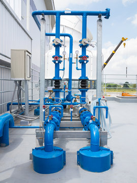 Water pump station and water cooling tower on roof deck of water tank. Including with electric motor, pipeline, valve control and electrical control box for water cooling system of industry process.
