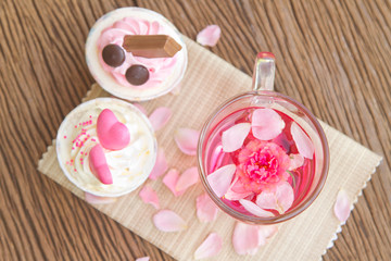 Rose tea  and sweet cupcake on table in the garden,Beautiful tea