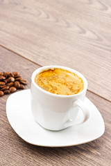 cup of coffee and coffee beans on wooden table