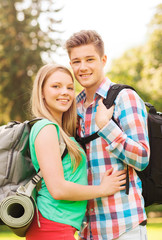 smiling couple with backpacks in nature