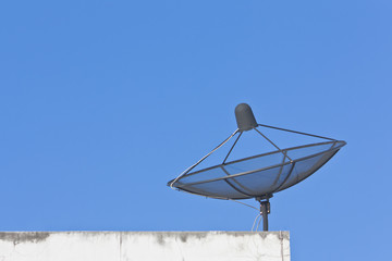 Satellite dish on roof top with blue sky