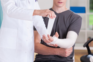 Doctor making cast of upper limb