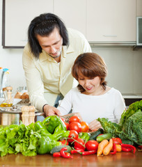 woman with handsome husband cooking with fresh vegetables