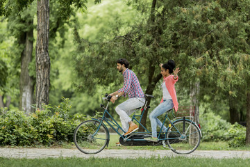 Fototapeta na wymiar Young couple riding on the tandem bicycle