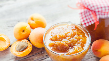 apricot fruits and jar of jam on table