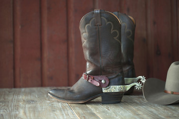 Cowboy boots, spurs and hat on old wood background - obrazy, fototapety, plakaty