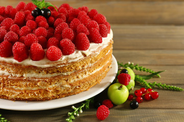 Tasty cake with fresh berries on wooden table