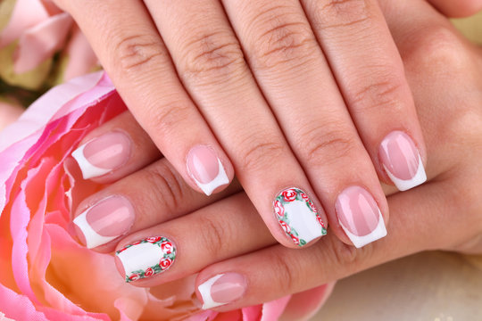 Female hand with stylish colorful nails  with decorative flower