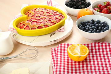 Baking tasty pie and ingredients for it on table in kitchen