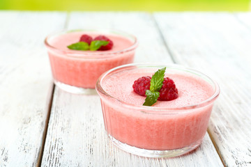 Delicious berry mousse in bowls on table close-up