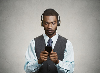 Naklejka premium Phone addicted businessman with headphones, grey background