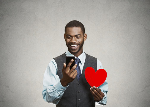 Happy Man checking his smart phone, holding red heart