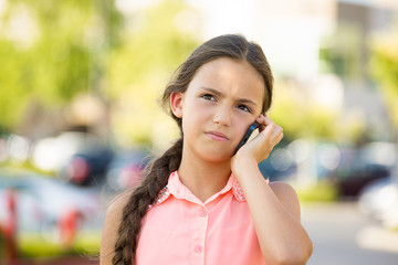 Unhappy, sad girl talking on smart phone, outside background 