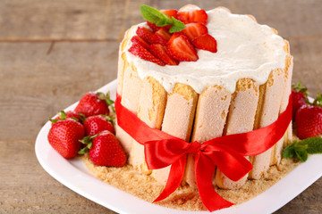 Tasty cake Charlotte with fresh strawberries on wooden table