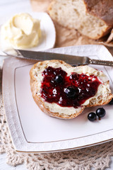 Fresh bread with homemade butter and blackcurrant jam