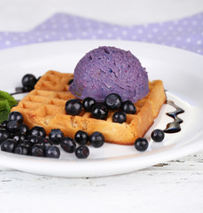 Tasty belgian waffles with ice cream on wooden table