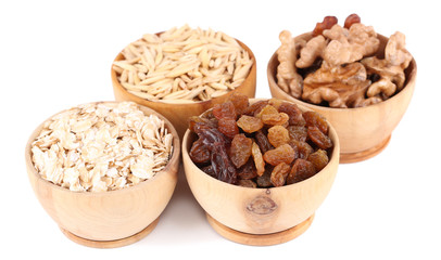Small wooden bowls with raisins, walnuts and oats isolated
