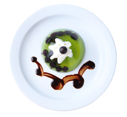 Green jelly with blackcurrant berries and sauce, isolated