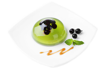 Green jelly with blackcurrant berries and sauce, isolated