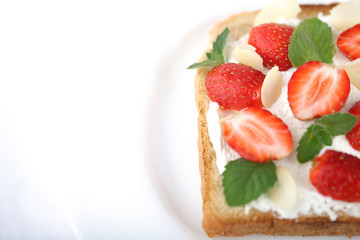 Бутерброд из белого хлеба и творожного сыра с ягодами клубники