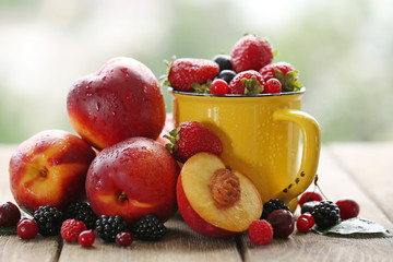Peaches and berries on table on natural background