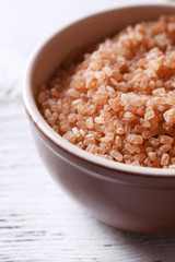 Crystal sugar in bowl on wooden background