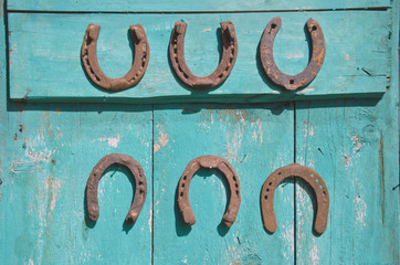 six antique rusty horseshoe on wooden door