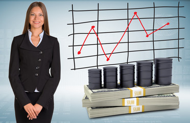 Businesswoman with barrels oil and money