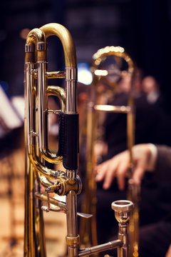 Trombones in the hands of musicians on stage