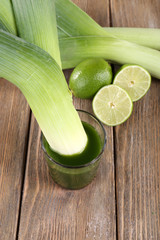 Spring onions in a glass of fresh vegetable juice and lime