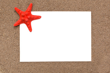 White sheet of paper with a starfish on the sand