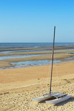 Segelkatamaran auf dem Strand mit Meereshintergrund