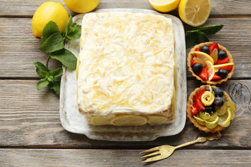 Tasty lemon cake on table at home