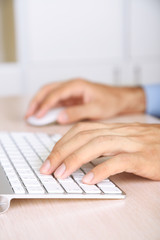 Man working with keyboard on wooden table closeup