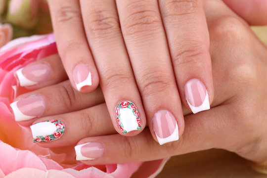 Female hand with stylish colorful nails  with decorative flower