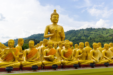 golden statue of monks and buddha