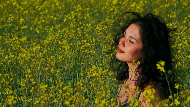 Ecology. Thoughtful woman is in a field of Raps.