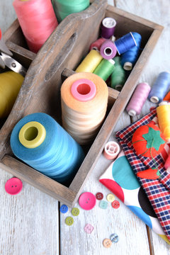 Sewing Accessories in wooden box on table close-up